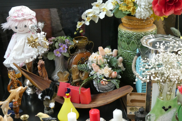 Flohmarktwaren, wie Puppen, Kunstblumen und Schmuck.